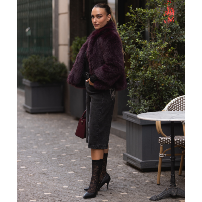 Mulher elegante de casaco roxo escuro na rua com bolsa vinho e saia preta