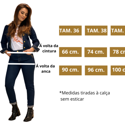 Mulher com calças de ganga pretas e tabela de tamanhos ao lado