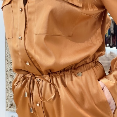 Conjunto de roupa de pele sintética cor caramelo com botões metálicos prateados e cordão na cintura