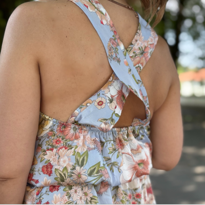 Top ou vestido azul-claro com padrão floral e alças cruzadas nas costas, visto de perto
