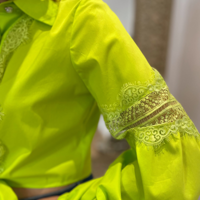 Camisa amarela fluorescente com detalhes em renda na manga.