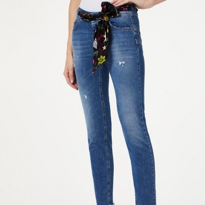 Calças de ganga azuis justas com cinto de tecido estampado preto e salto alto preto