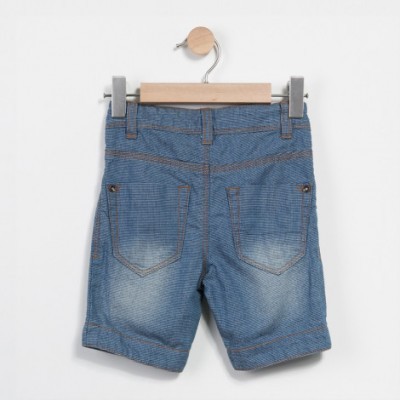 Calção de jeans azul claro pendurado numa cabide de madeira