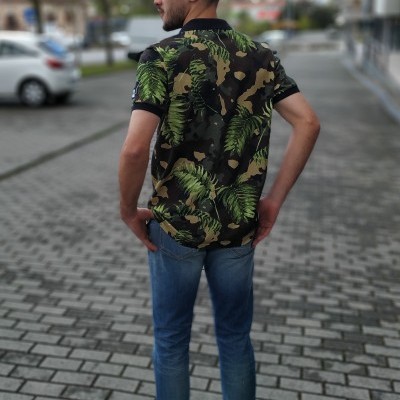 Homem de costas com camisa camuflada e calças de ganga na calçada