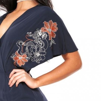 Macacão azul escuro com bordado floral na manga