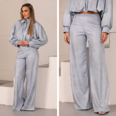 Conjunto feminino azul claro com casaco e calças largas em interior com escadas brancas