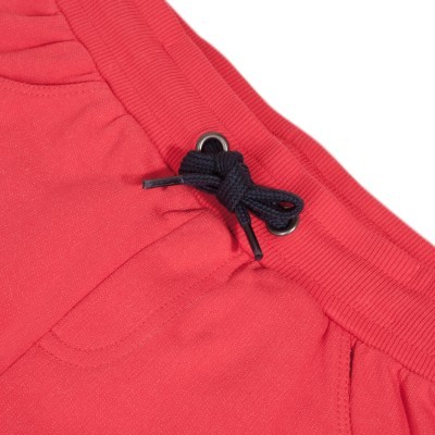 Detalhe de calça ou calção vermelhos com cós elástico e cordão preto amarrado