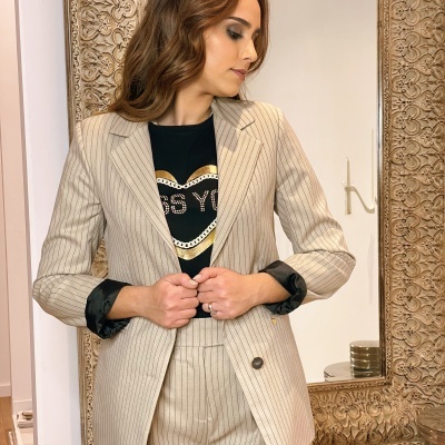 Fato bege às riscas com blazer e calças combinado com t-shirt preta com texto MISS YOU em coração dourado e branco