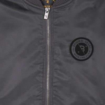 Casaco cinza escuro com fecho de correr e emblema circular preto no peito