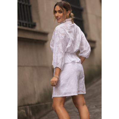 Conjunto branco feminino bordado com camisa e calções, usado em ambiente urbano