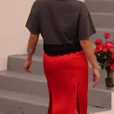 Mulher com saia vermelha e t-shirt cinzenta com estampa MISS YOU
