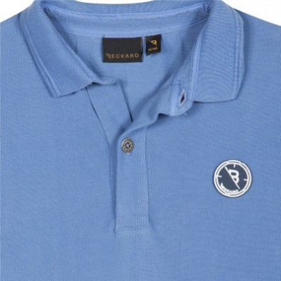 Polo azul claro com colarinho e botão, logótipo RB
