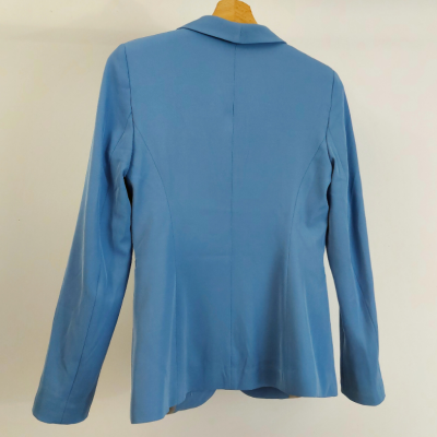 Blazer azul claro feminino de costas em cabide de madeira