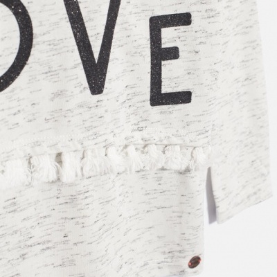 Pormenor de t-shirt cinza claro com franjas e letras pretas