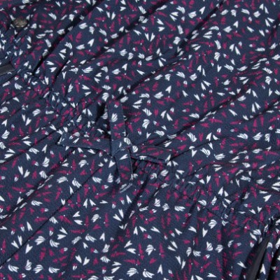 Tecido azul escuro com padrão de folhas brancas e vermelhas e fita amarrada ao centro