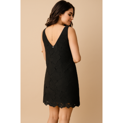 Vestido preto texturizado com padrão floral, visto pelas costas em fundo bege.