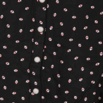 Roupa preta com padrão de triângulos rosa e branco e botões brancos