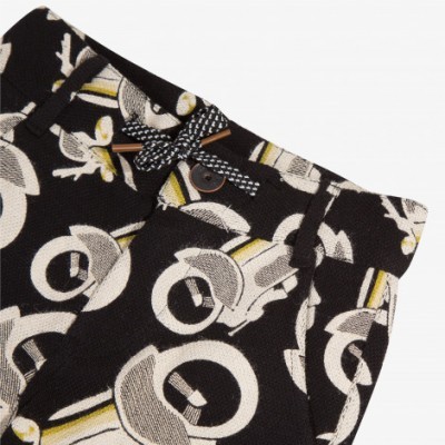 Calças com padrão gráfico preto, branco e amarelo e laço preto e branco