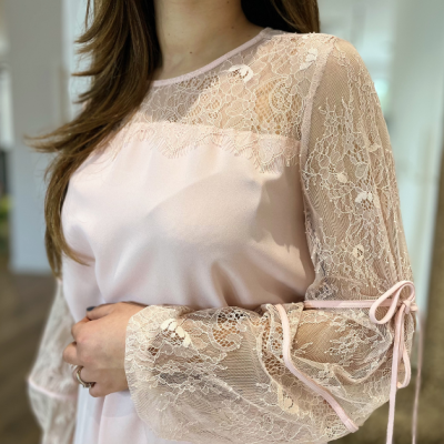 Blusa feminina rosa clara com mangas em renda e laços no punho
