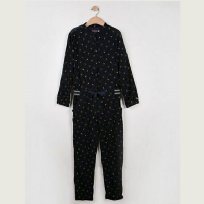 Macacão preto com padrão de flores coloridas e punhos risca branca e preta.