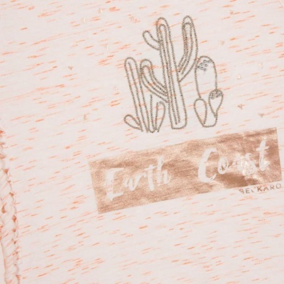 Peça de roupa bege com desenho de cactos e texto Earth Coast