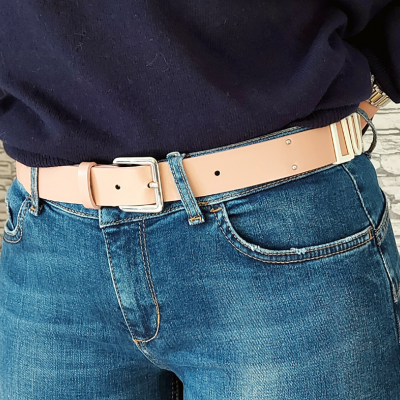Cinto de couro bege com fivela metálica e calças de ganga azuis