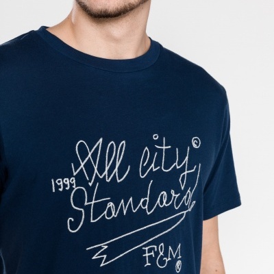 T-shirt azul escura com texto branco vestida por homem