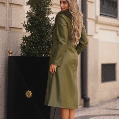 Mulher com casaco verde comprido de pele e golas de pele sintética castanha e botas de salto alto com padrão de animal print