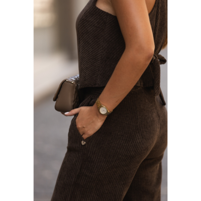 Conjunto castanho escuro canelado composto por calças e top com nó nas costas acompanhado por relógio dourado e mala castanha