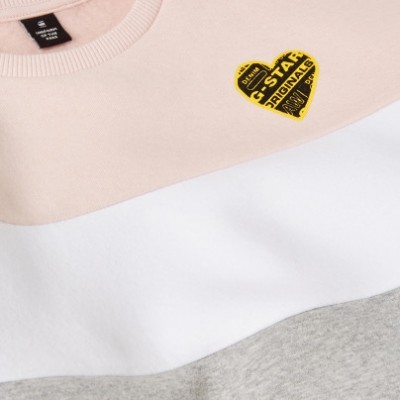 Camisola com faixas bege, branca e cinzento claro e coração amarelo com texto