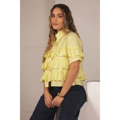 Casaco amarelo claro com folhos e botões usado por mulher