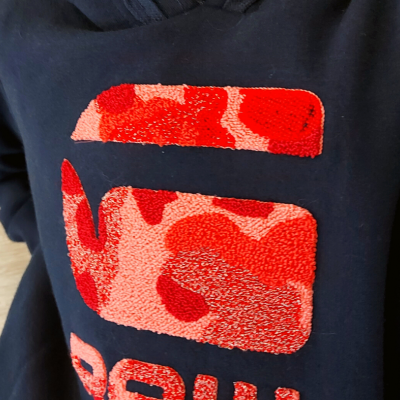 Capuz azul escuro com logotipo felpudo vermelho e rosa em padrão camuflado e texto 'ROW'