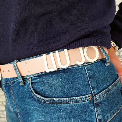 Cinto rosa claro de pele com letras douradas LIU JO usado com calças de ganga