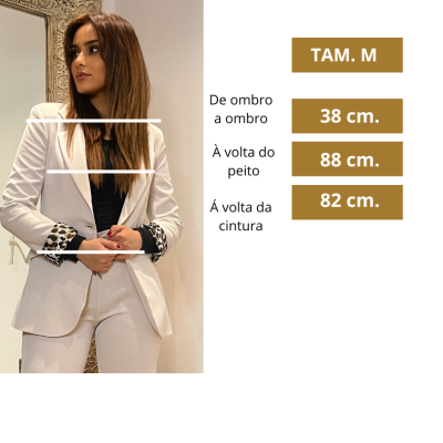 Mulher a usar fato bege tamanho M com padrão animal print nas mangas dobradas