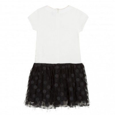 Vestido de criança branco com saia preta de bolinhas em fundo branco