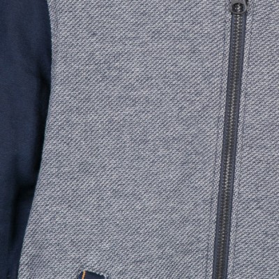 Casaco cinzento com padrão espinha e mangas azuis escuras com fecho de correr.