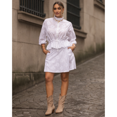 Vestido branco bordado floral com mangas bufantes e botas bege na rua.