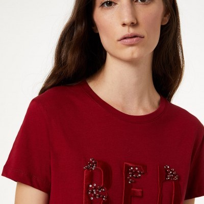 T-shirt vermelha com letras bordadas 'RED' decoradas com pérolas.