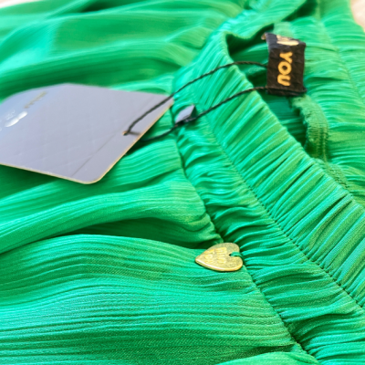 Vestido ou saia verde plissada com etiqueta 'you' e pendente dourado em forma de coração