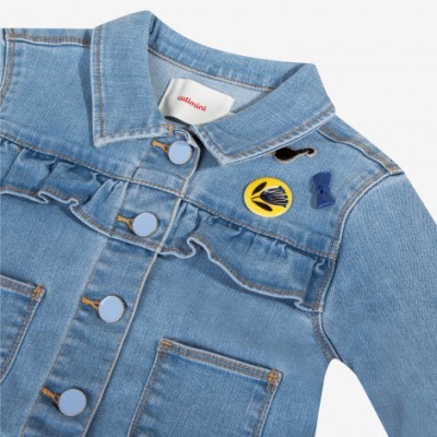 Casaco de ganga azul claro com botões azuis e distintivos coloridos