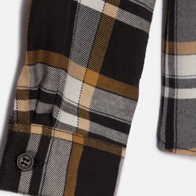 Punho de camisa xadrez preto, branco, cinza e castanho com botão