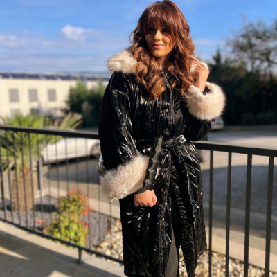 Casaco preto brilhante com pelo branco na gola e punhos