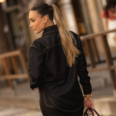 Casaco ou camisa de ganga preta vista de costas com costuras em contraste e cabelo apanhado