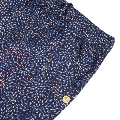 Calções azuis com padrão abstrato e botão dourado no bolso