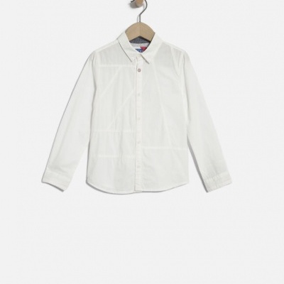 Camisa branca de manga comprida para criança em cabide