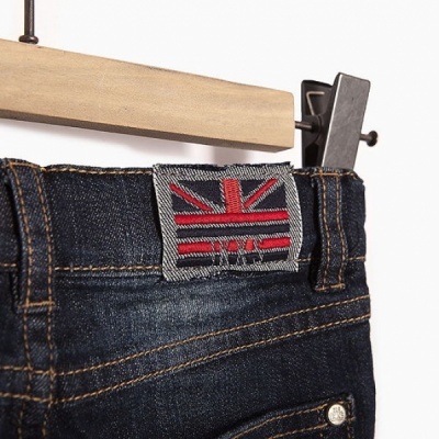 Calças de ganga azul escuro com etiqueta da bandeira do Reino Unido penduradas