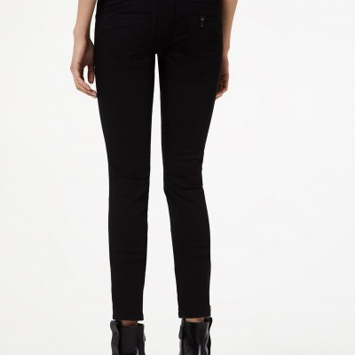 Calças pretas justas com botas pretas de salto em fundo branco