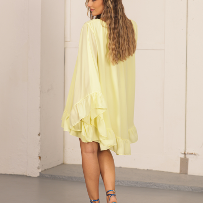 Vestido curto amarelo com mangas largas e folhos visto por trás