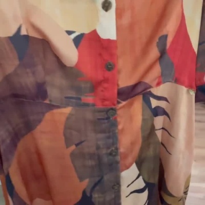 Camisa colorida com padrão abstrato e botões frontais.