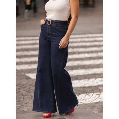 Calças de ganga largas azul escuro com cinto e blusa branca em passadeira